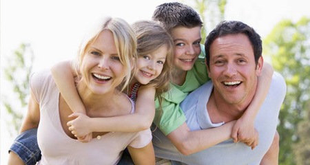 Smiling mother father and two kids outdoors