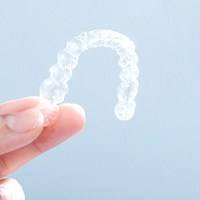 Patient holding up Invisalign in Bellevue