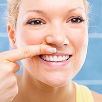 Woman looking at her gums in mirror