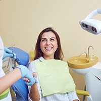 A woman smiling and shaking her dentist’s hand