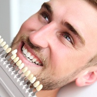 Patient comparing veneer shades with a cosmetic dentist in Bellevue