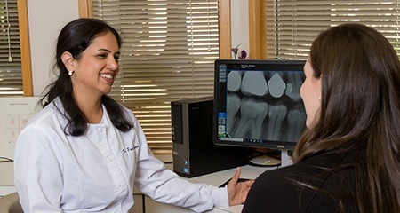 Dr. Taneja and patient looking at dental x-rays