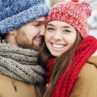 A young girl smiling while a boy smiles at her